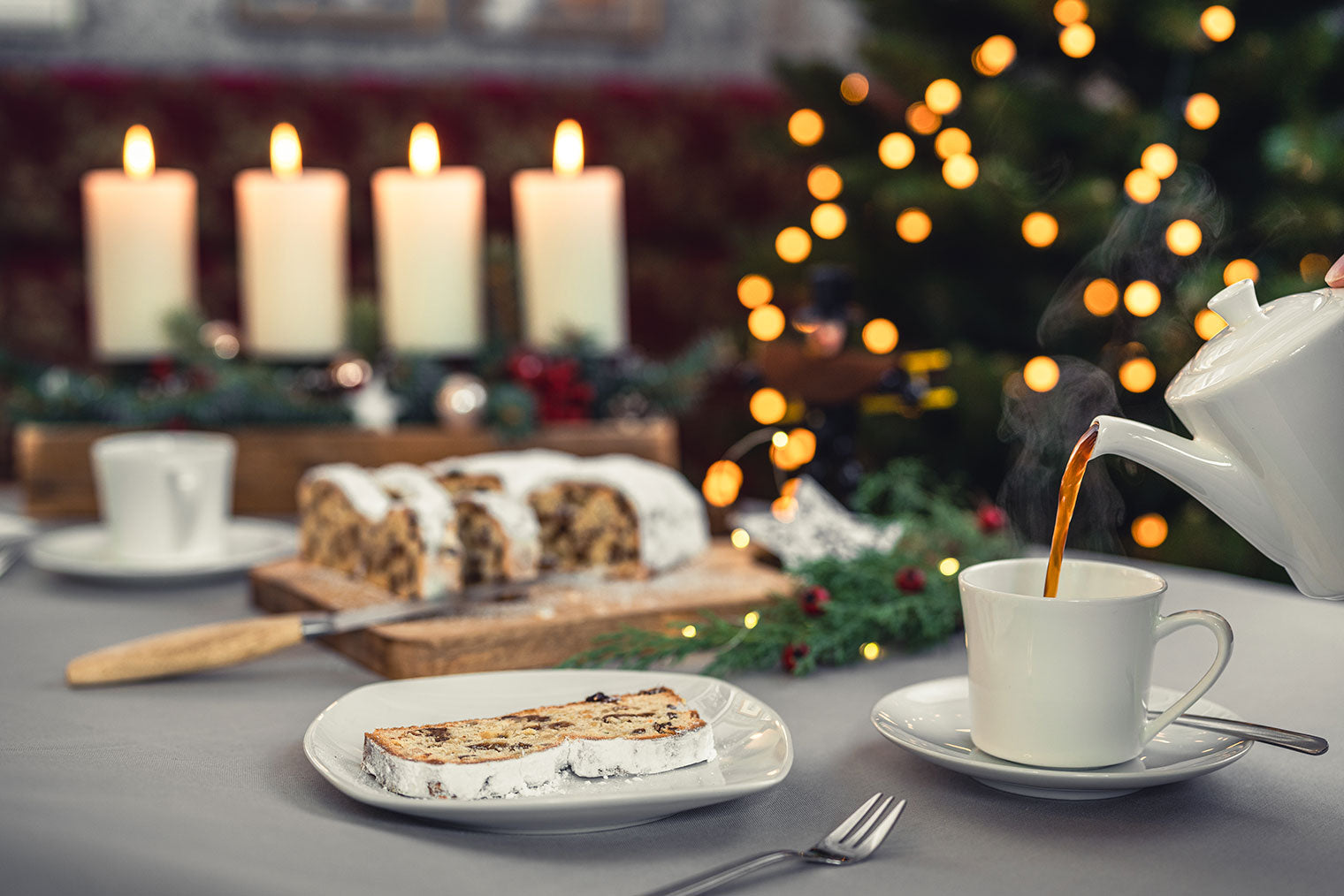 Aufgeschnittener dresdner Christstollen auf Holzbrett und servierfertig, Kaffee wird eingegossen
