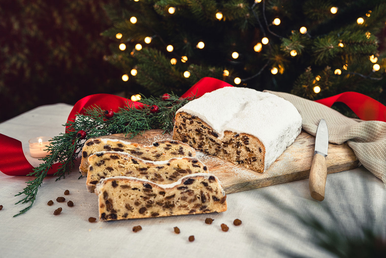 Aufgeschnittener dresdner Christstollen auf Schneidebrett, präsentiert in weihnachtlicher Stimmung