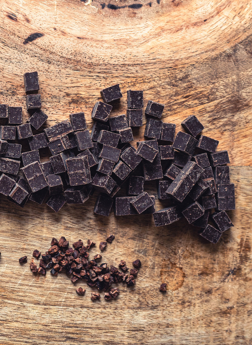 Dunkle Belgische Schokoladenwürfel auf hölzernem Tisch